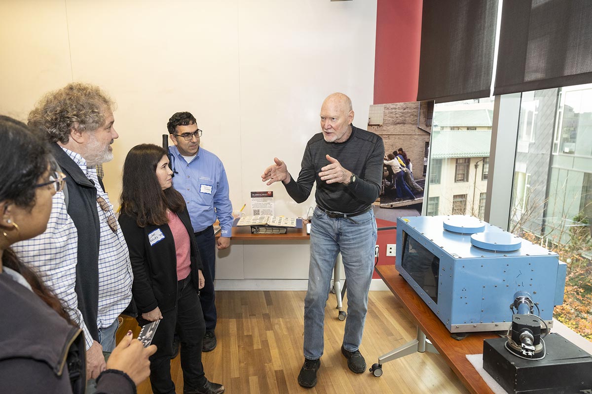 William “Red” Whittaker, Faculty Emeritus and founding director of the Field Robotics Center, speaks to a group including Bruce Eppinger (CIT ‘86), Rachel Reinitz (CIT ‘87), and Steve Berman (CIT ‘91) about the blue sensor beside him. The sensor is an early laser scanner created by the Environmental Research Institute of Michigan.