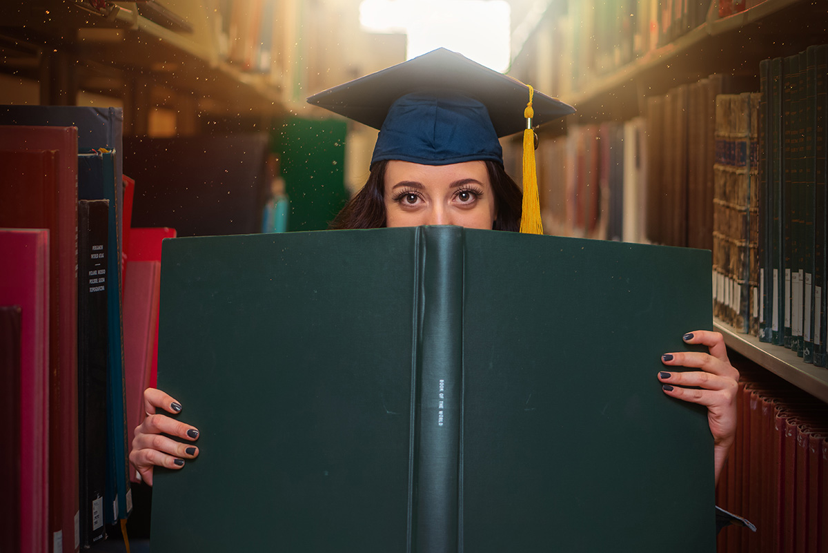 College student hiding behind a book