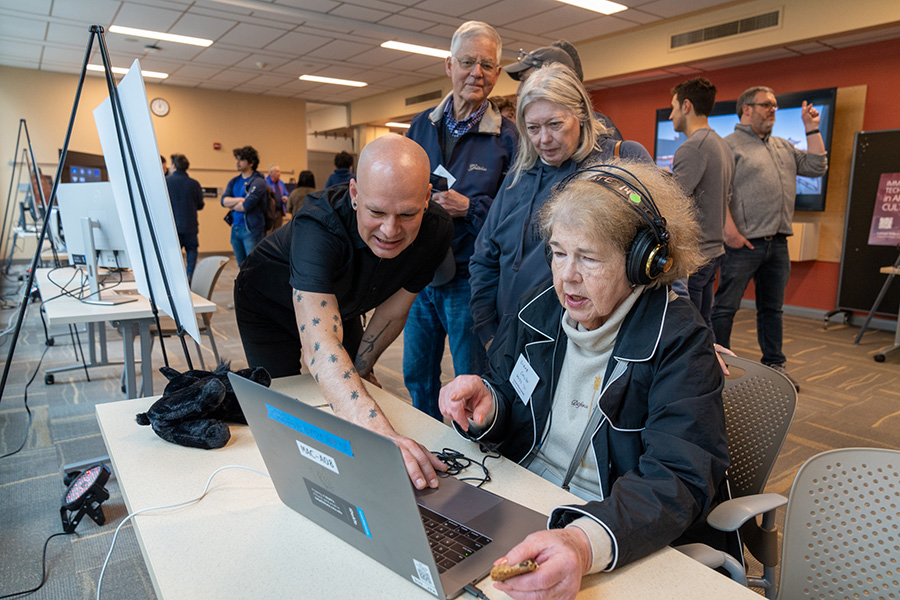 IDeATe Academic Coordinator Ryan M. McKelvey assists alumni visitors with game play on a new 3D RPG built in Unity.