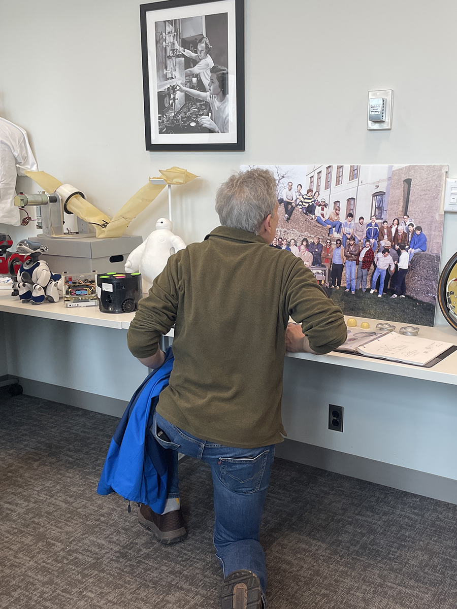 An attendee views a photo of members of the Field Robotics Center outside Hamerschlag Hall with the Terregator robot.