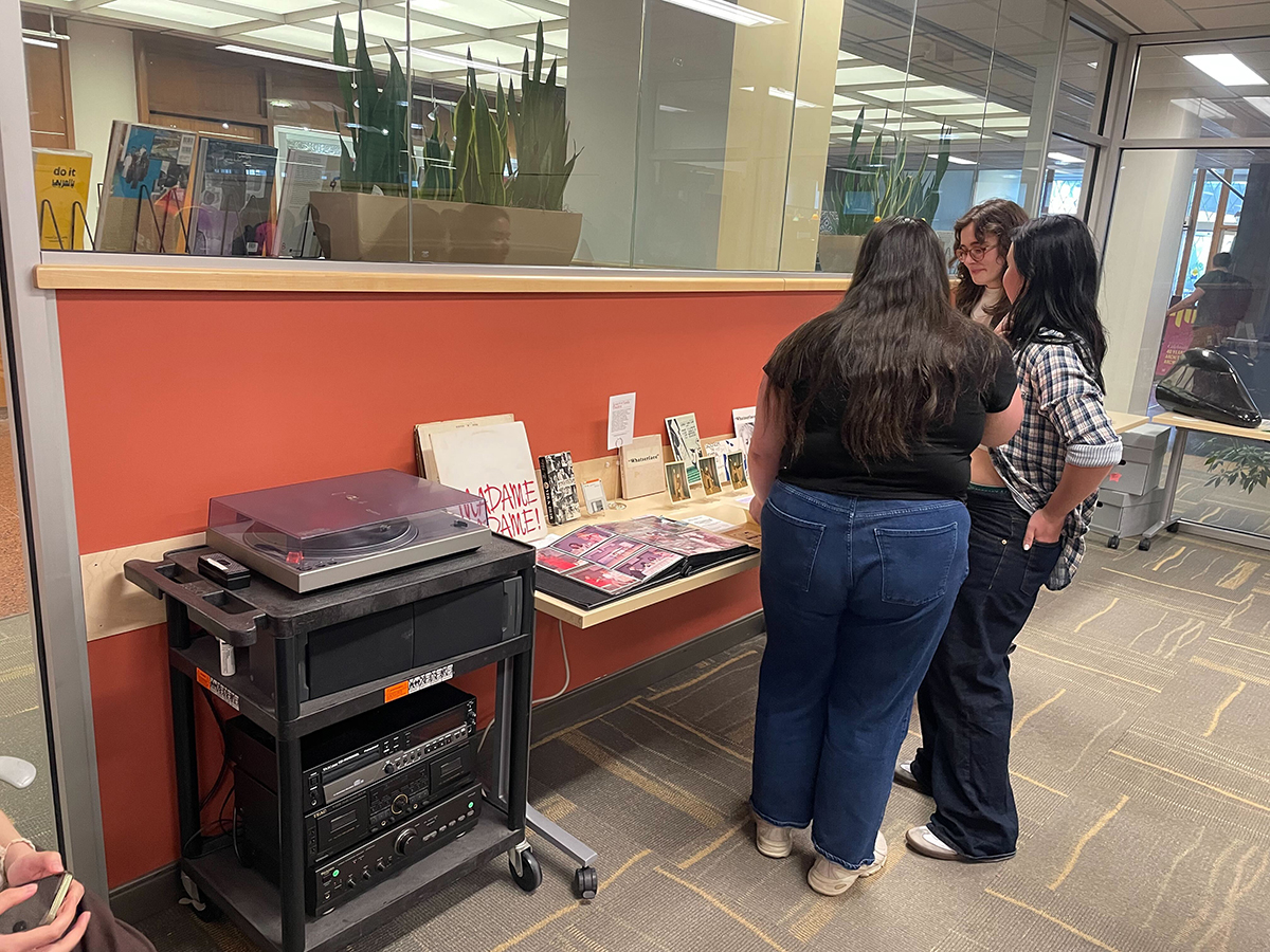 A group of students examines items from Scotch’n’Soda Theatre, including a record and program from “Pippin, Pippin,” the original version of the musical “Pippin” written by Stephen Schwartz. Schwartz is a 1968 graduate of the College of Fine Arts.